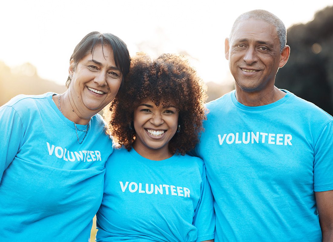 Non-Profit House of Worship Insurance - Portrait of Three Cheerful Diverse Volunteers Standing in the Park on a Sunny Day
